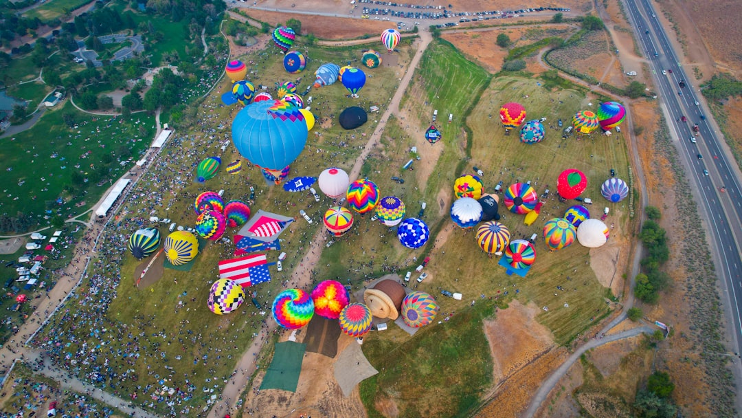Aerial view of dozens of hot air balloons on a launch field