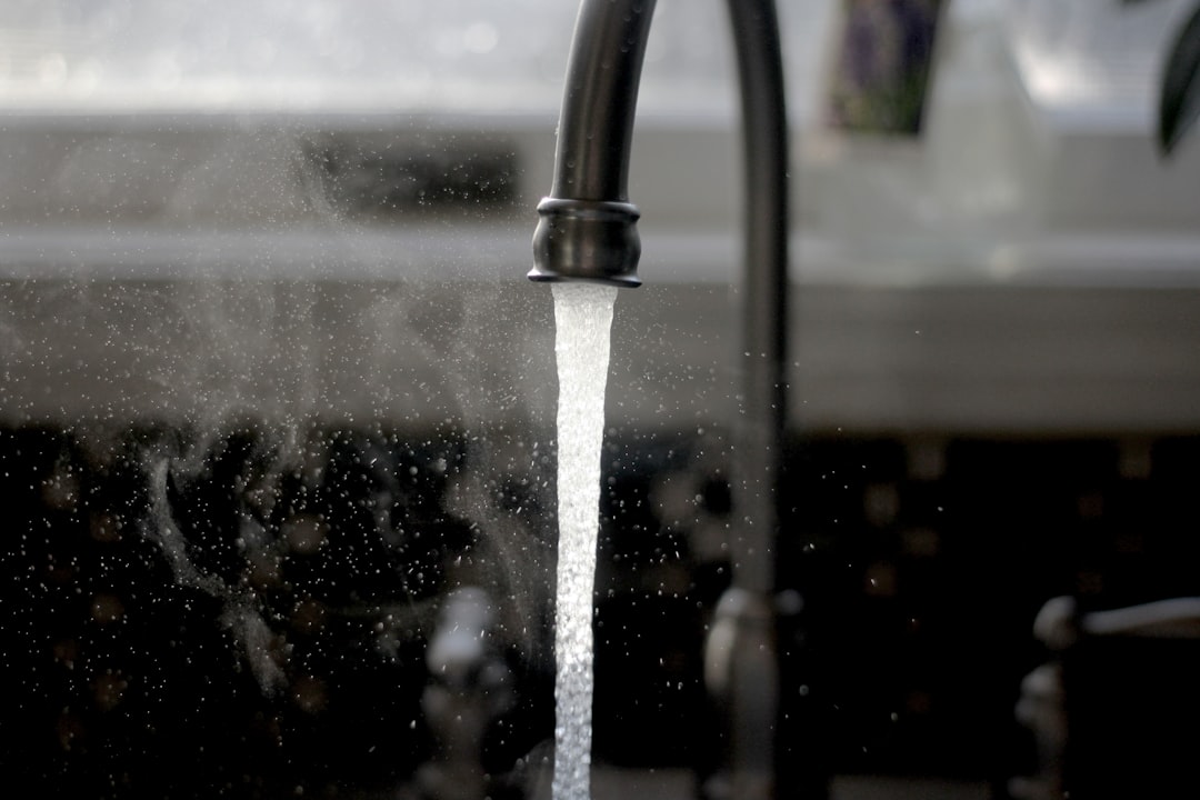 Water flowing from a faucet into a container