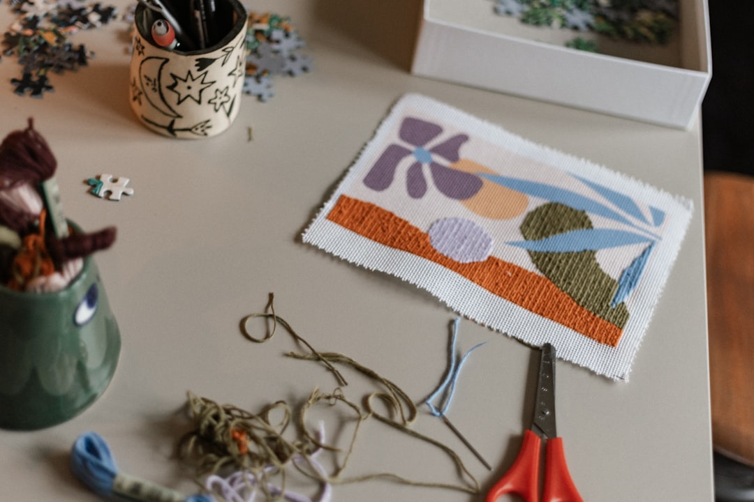 Craft table with scissors, fabric pieces, and sewing supplies for making patterns
