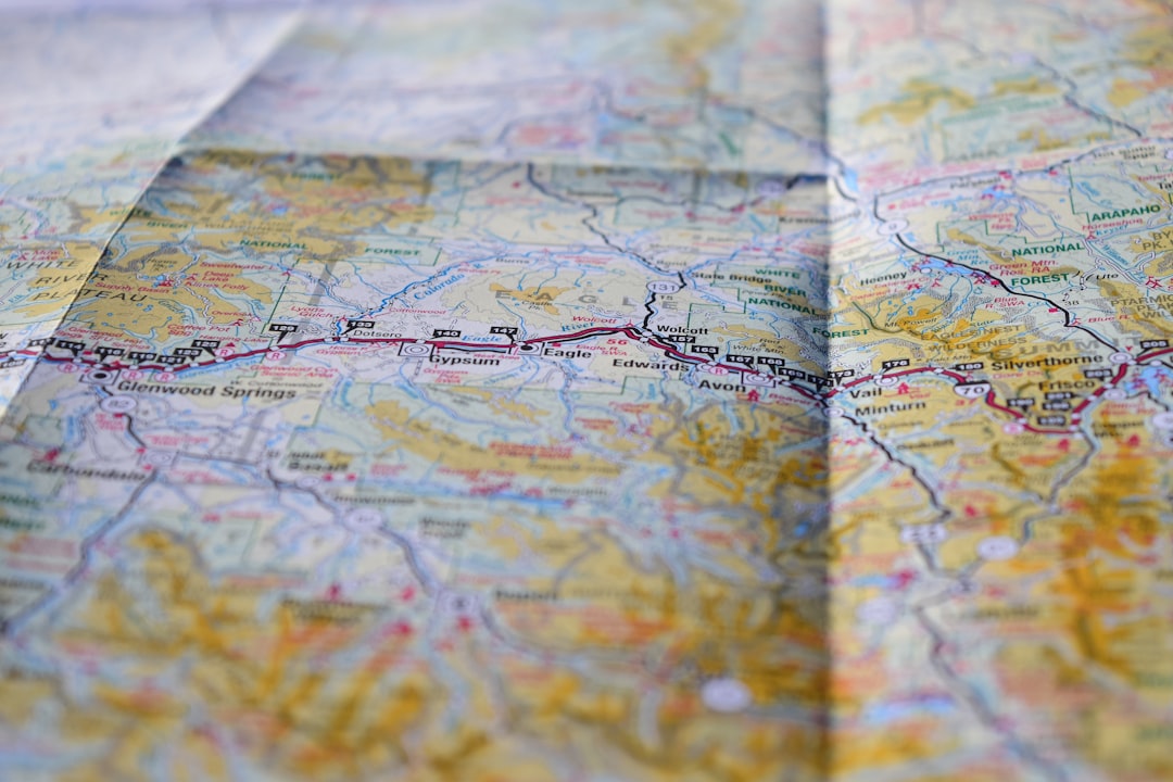A road atlas spread open on a car seat, route highlighted for trip planning