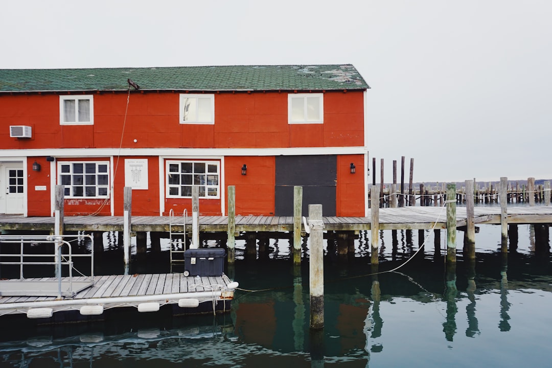 Red fishing shed on a quiet pier over calm coastal water