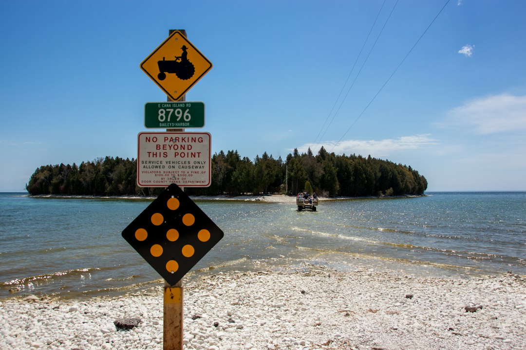 Rocky causeway crossing to a wooded island, the approach to Cana Island Lighthouse