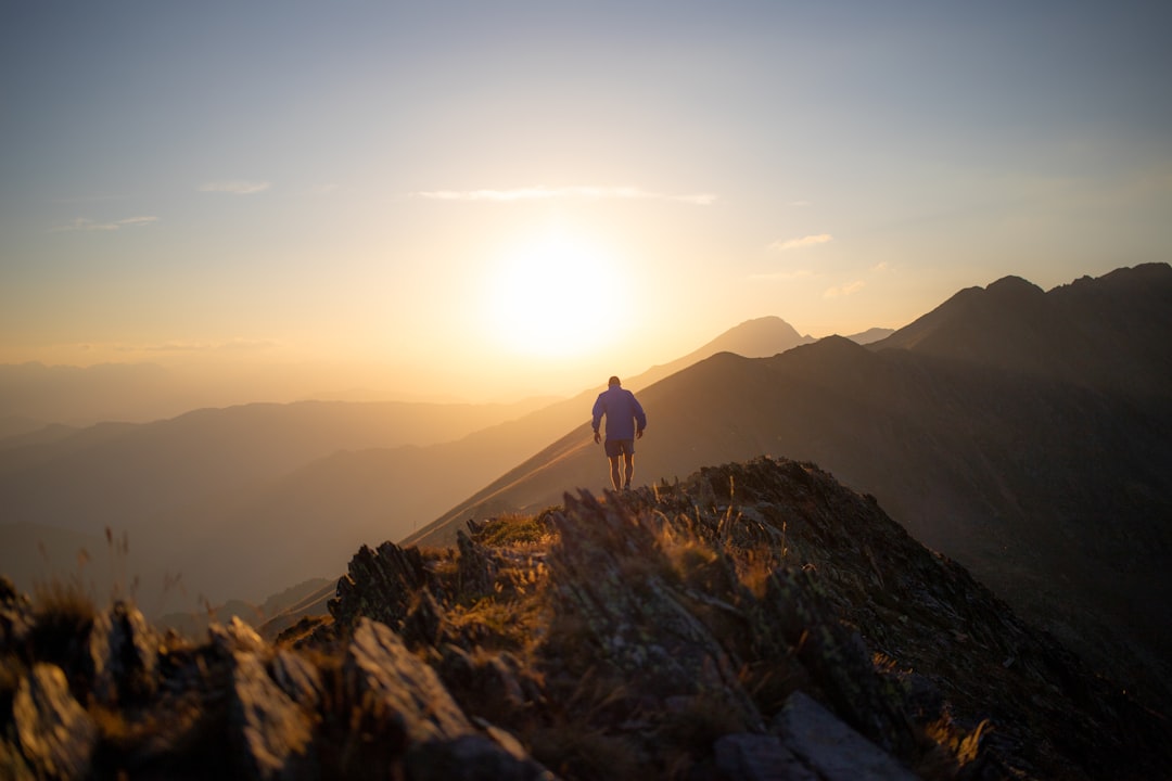 Hiker silhouetted on a rocky mountain ridge at sunset