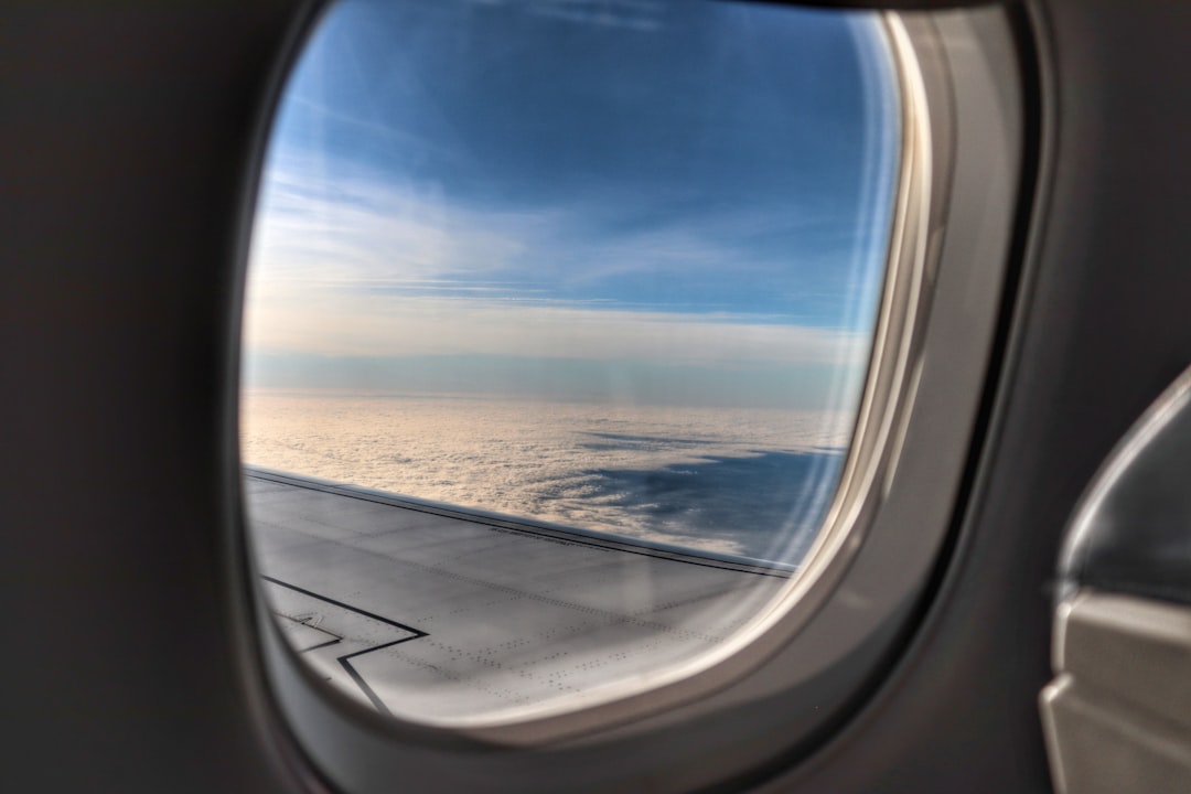 View through an airplane window seat above the clouds
