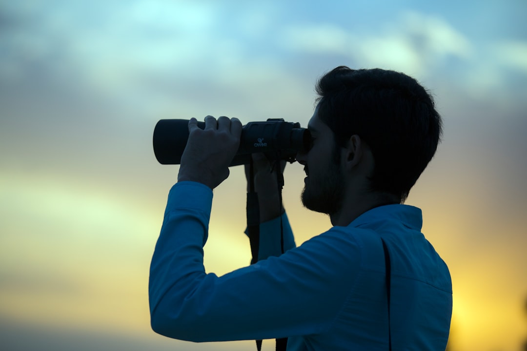 Observer with binoculars at sunset