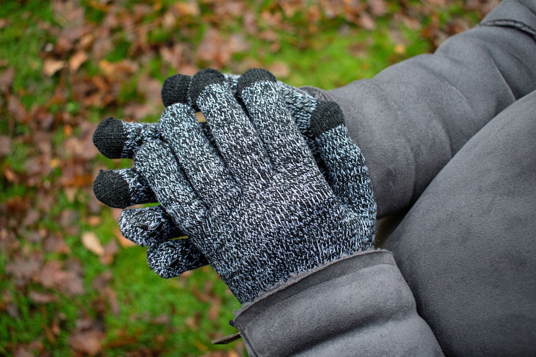 Hands wearing textured merino wool gloves with touchscreen fingertips