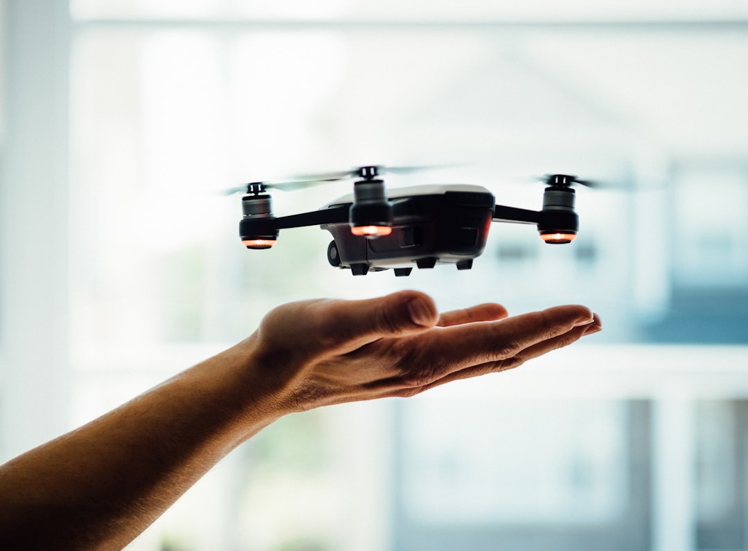 Mini camera drone resting on an open palm before launch