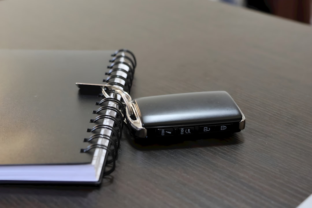 Tracker tag attached to keys beside a travel notebook