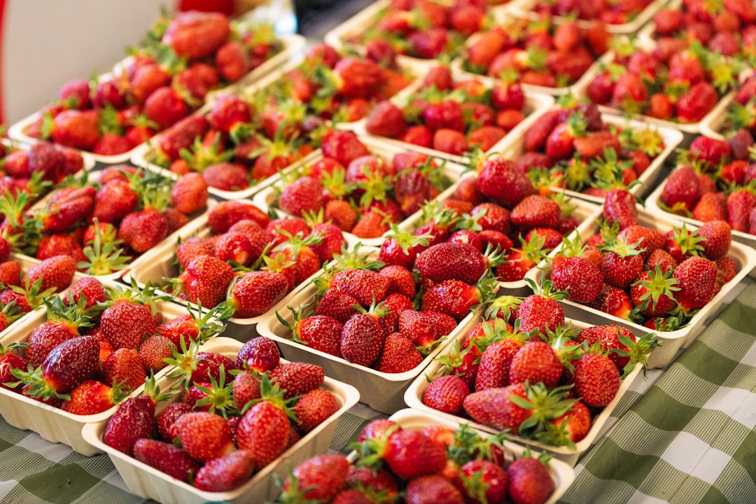Rows of strawberry baskets lined up on a market table