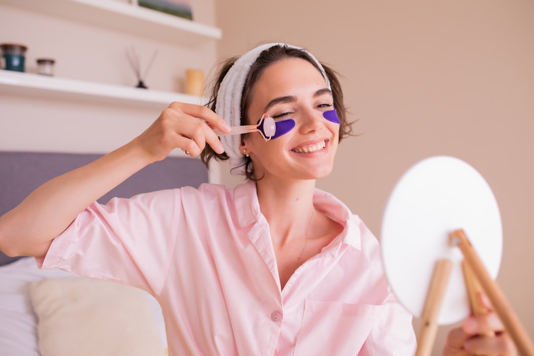 Woman applying under-eye patches in front of a mirror