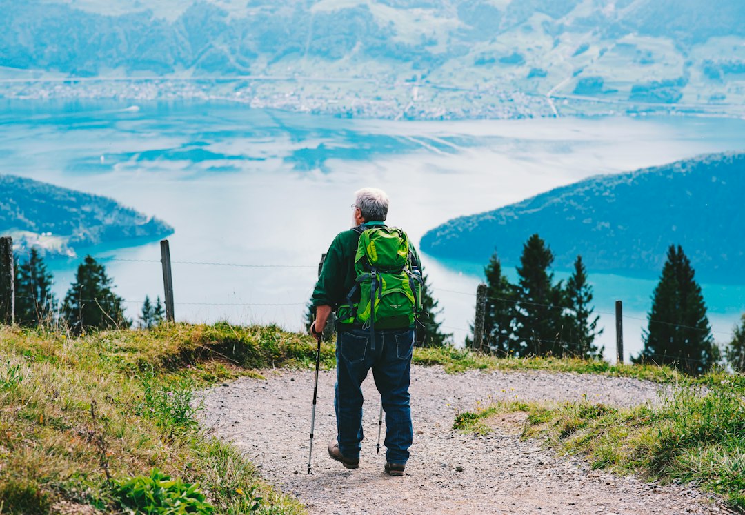 Senior hiker with a backpack walking a scenic ridge trail with poles