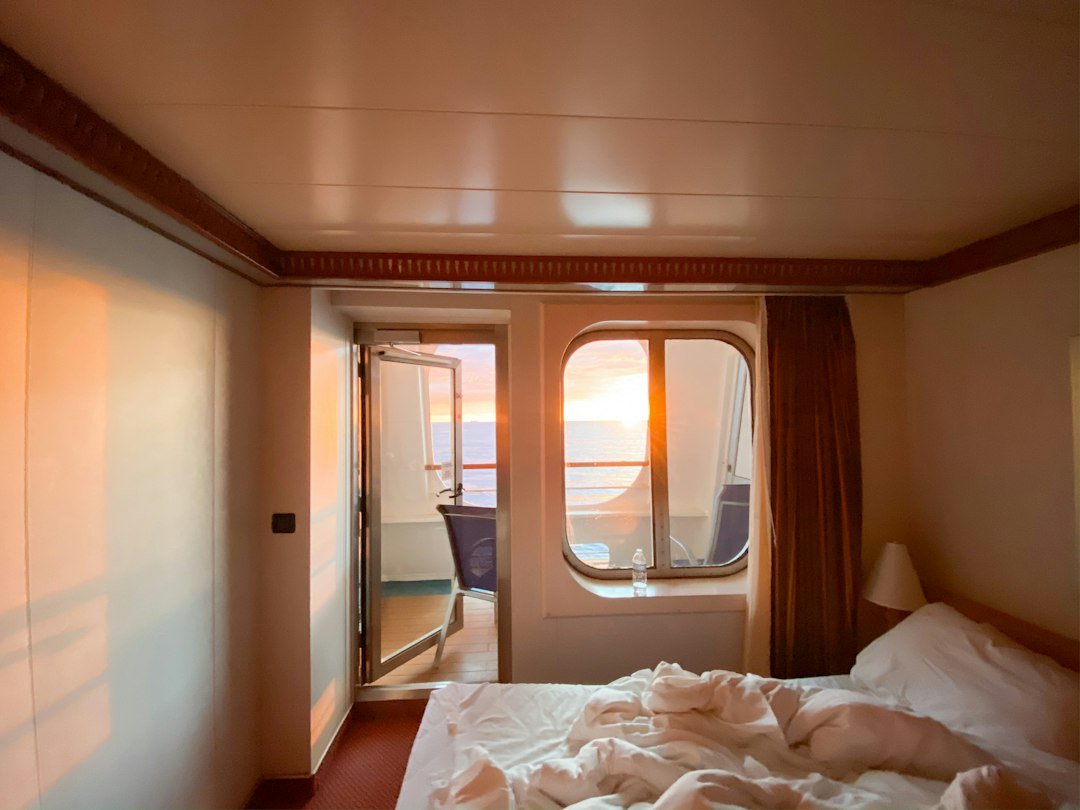 Cruise ship stateroom cabin interior with bed and ocean view