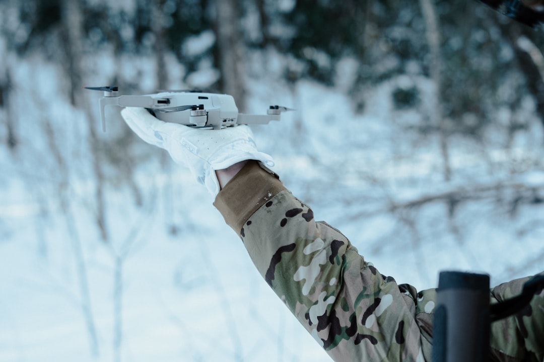 Traveler launching a small camera drone in an open outdoor landscape