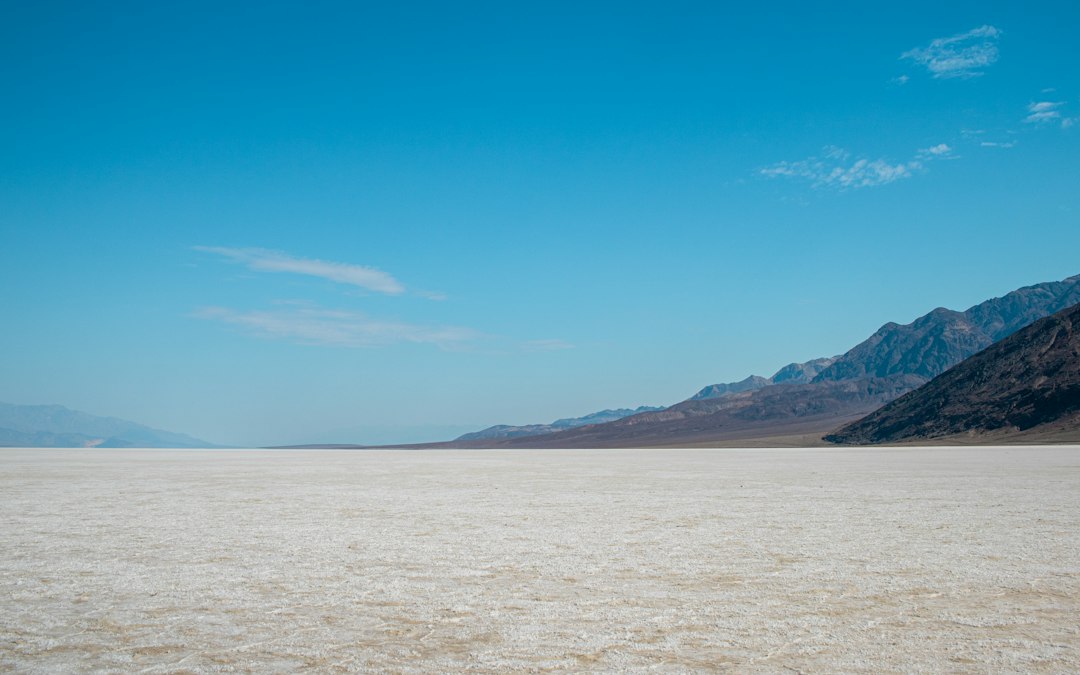 White salt flats of Badwater Basin stretch toward distant mountains below sea level