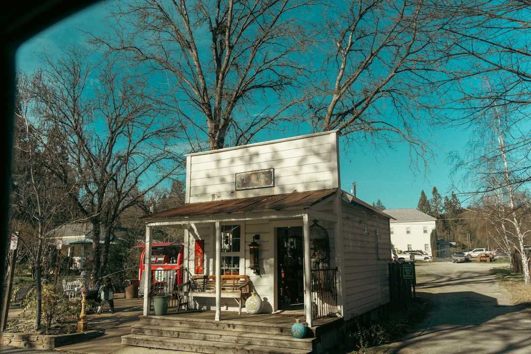 White clapboard store with a wooden porch in autumn