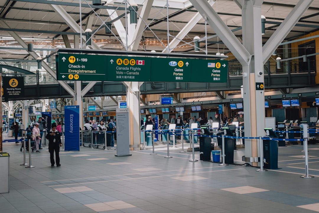 Busy airport check-in hall with travelers and departure signs