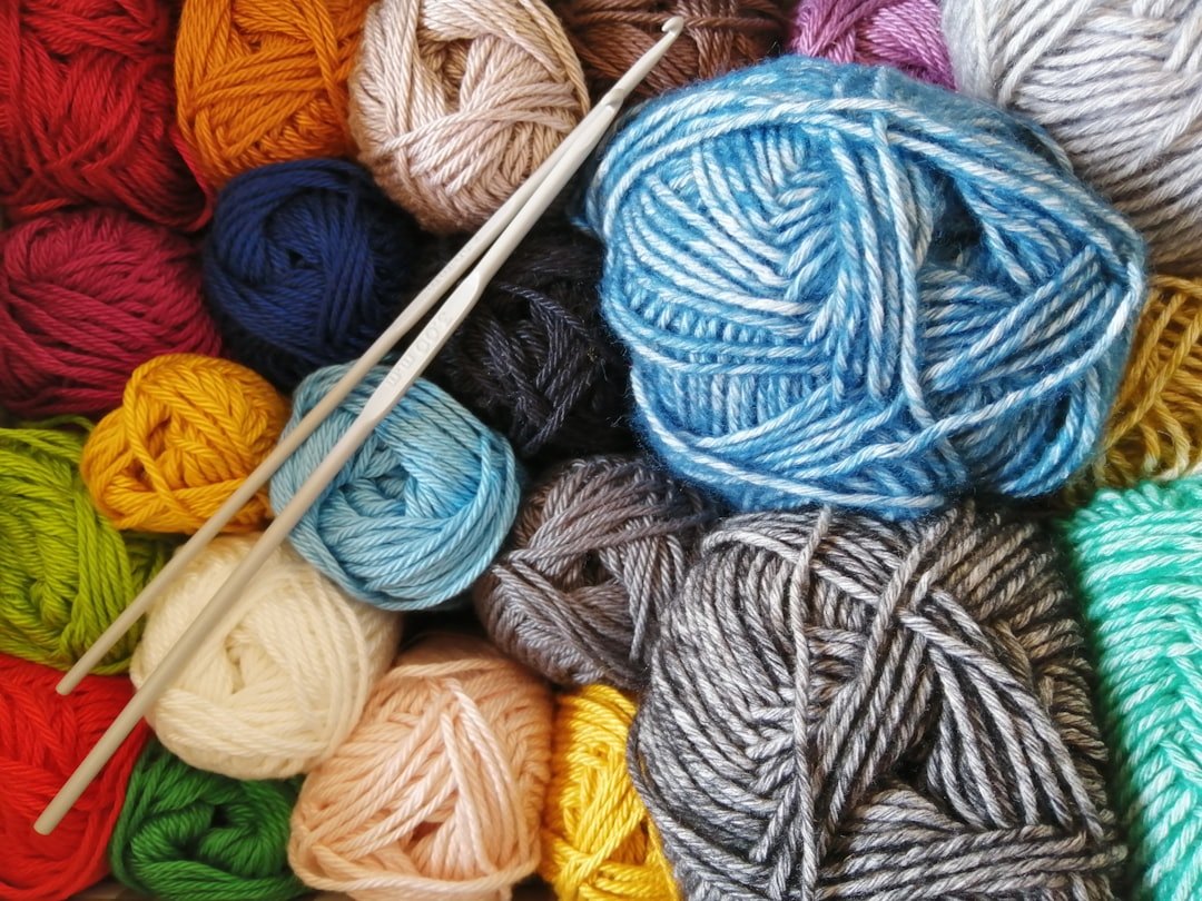 Colorful balls of merino wool yarn with knitting needles