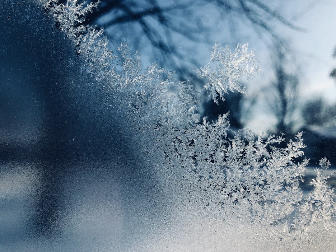 Frost crystals covering a vehicle windshield on a cold morning