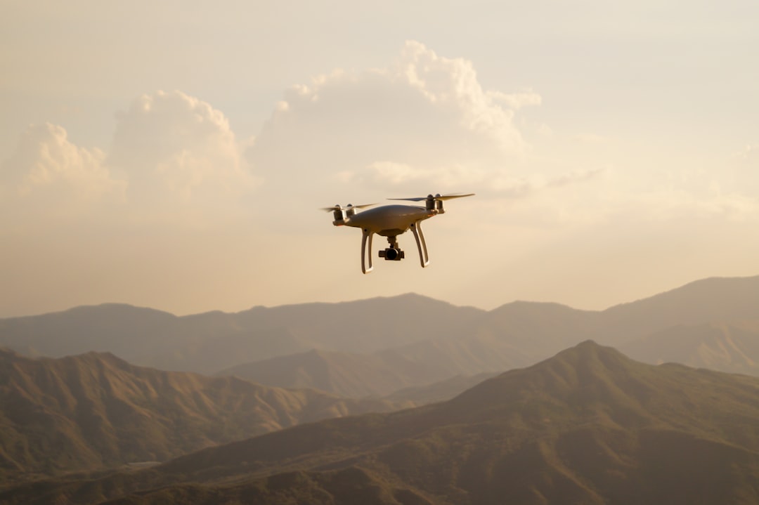 Small drone hovering in a bright sky at dusk