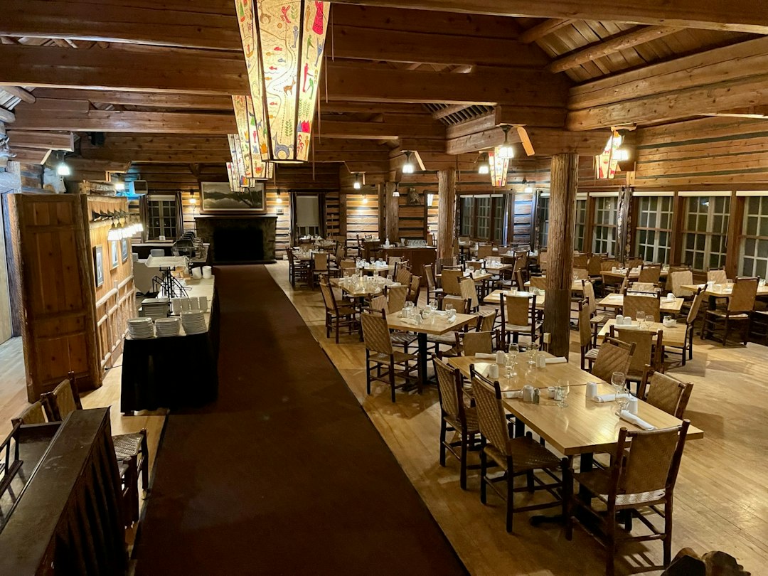 Rustic lodge dining room with log beams and long tables