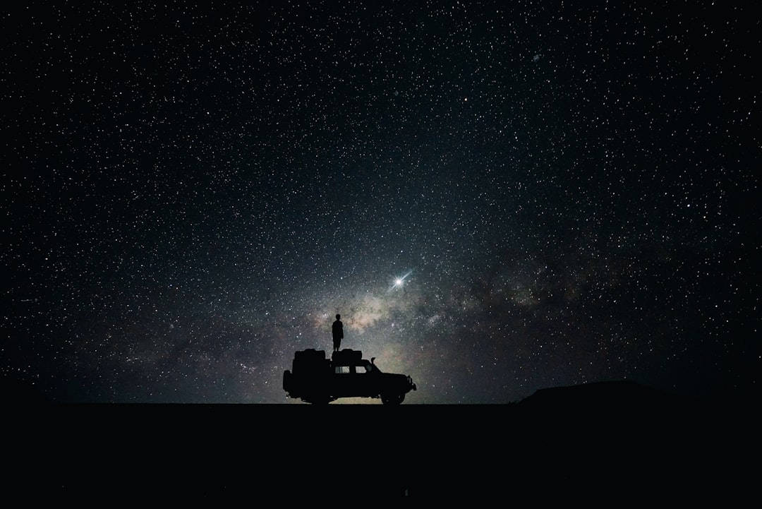 Silhouette of a stargazer under a night sky full of stars
