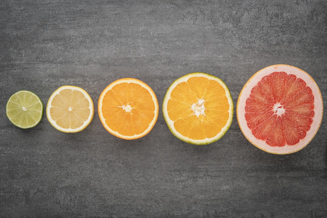 Sliced citrus fruits from lime to grapefruit arranged in a color gradient