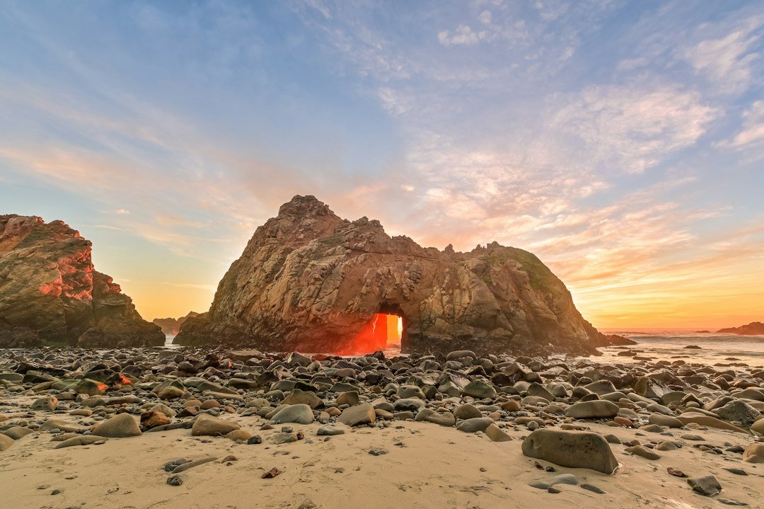 Natural keyhole arch rock formation on a Big Sur beach