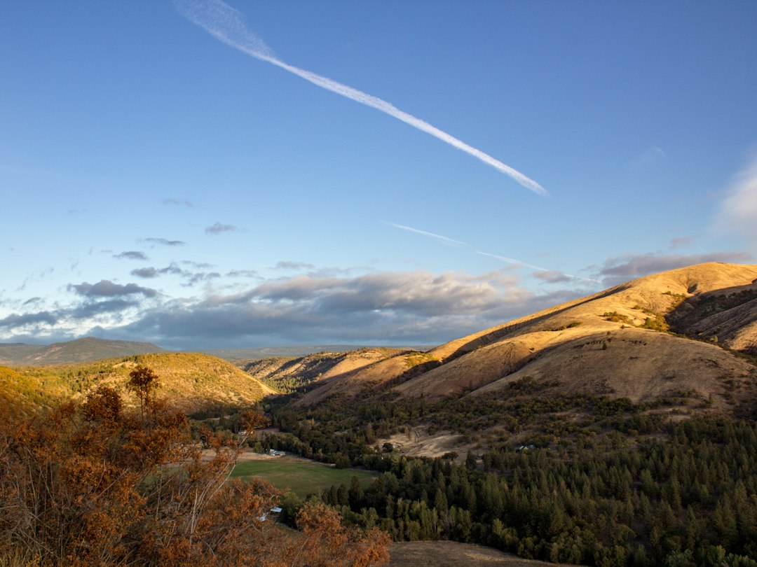 Wide autumn valley viewed from a scenic overlook above treetops