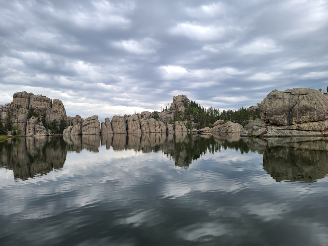 Granite rock formations reflected in the still water of a mountain lake