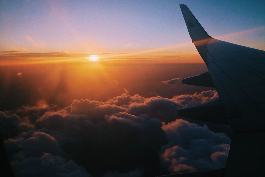 Golden sunrise seen through an airplane window above the clouds