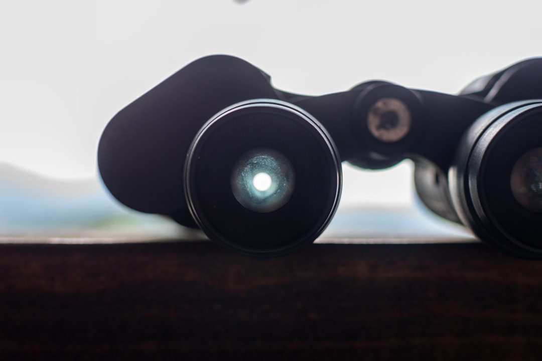 Compact binoculars resting on a wooden table before a day of glassing