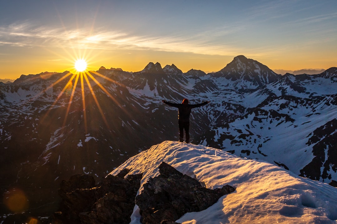 Hiker crossing a mountain slope in warm golden hour light