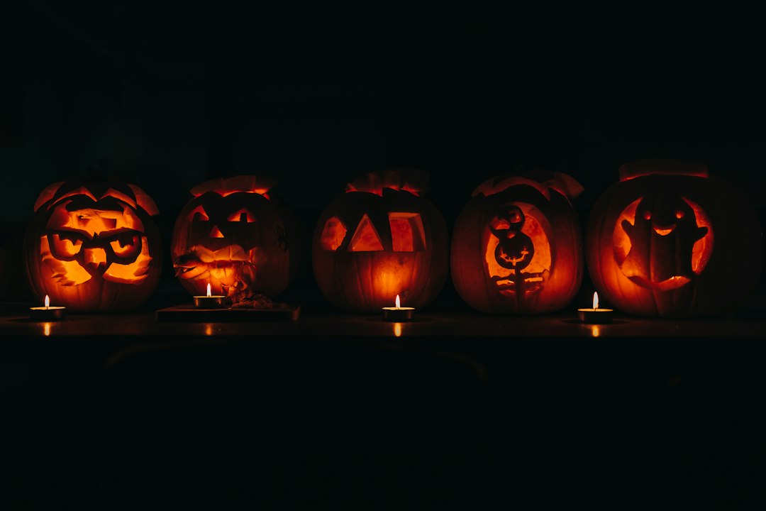 Carved jack o lantern pumpkins glowing in a night display
