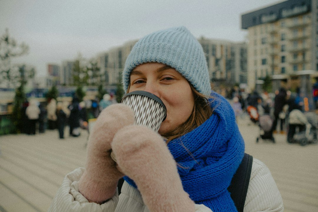 Mittens wrapped around a steaming cup on a cold morning