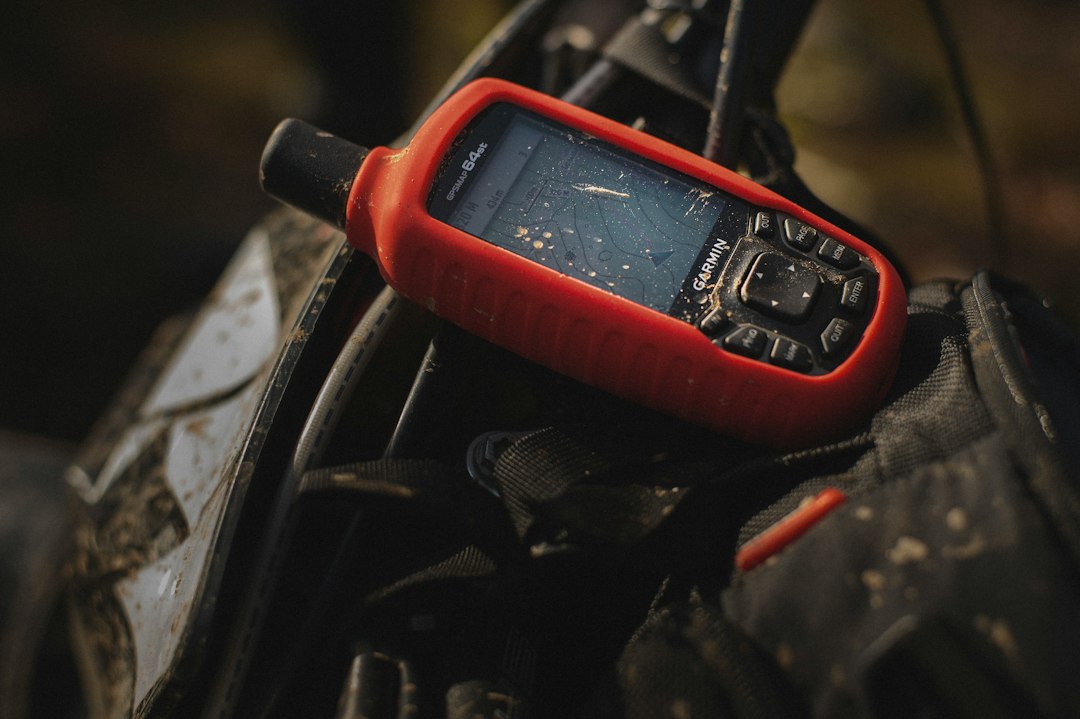 Hiker checking a handheld GPS device on a mountain trail