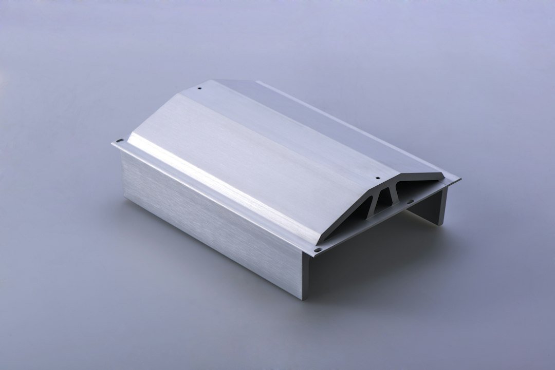 Close-up of a silver extruded aluminum T-slot profile showing channels and mounting holes