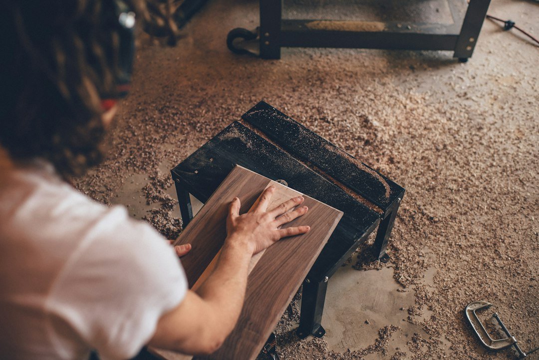 Overhead view of woodworking in a sawdust-covered workshop