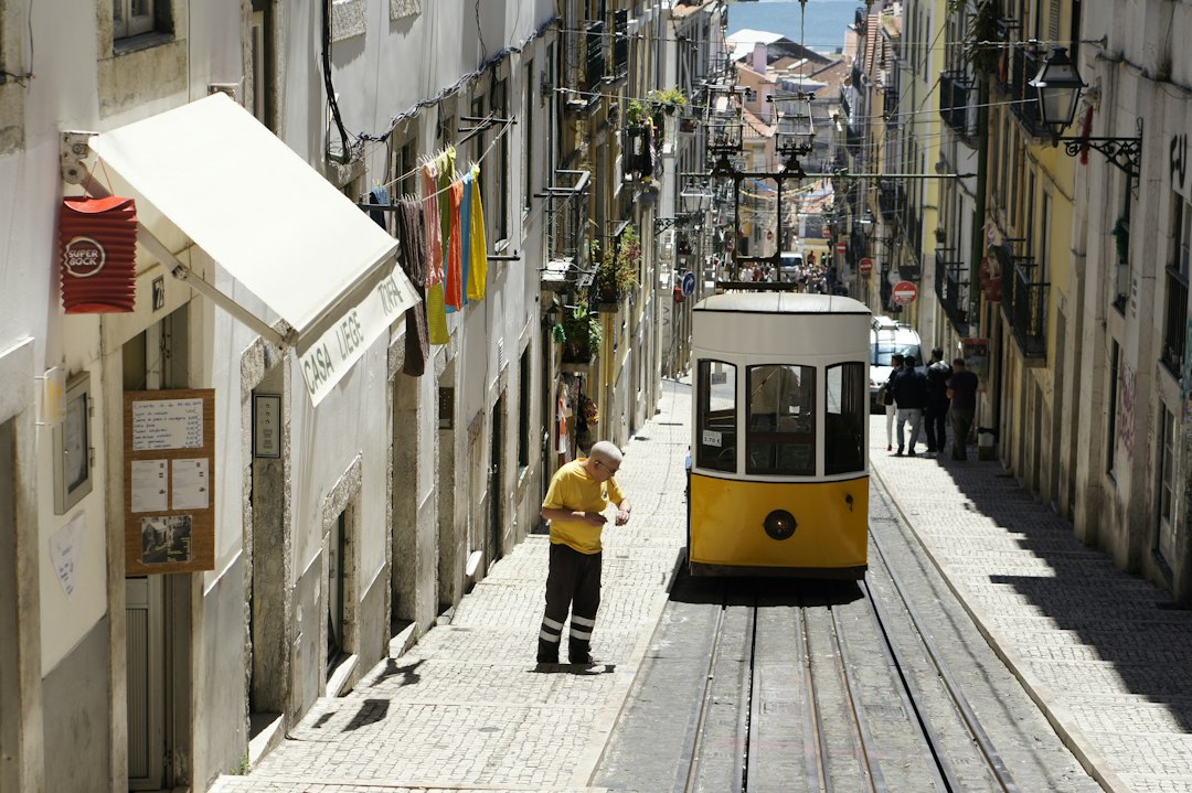 Narrow Lisbon street with tram and laundry overhead