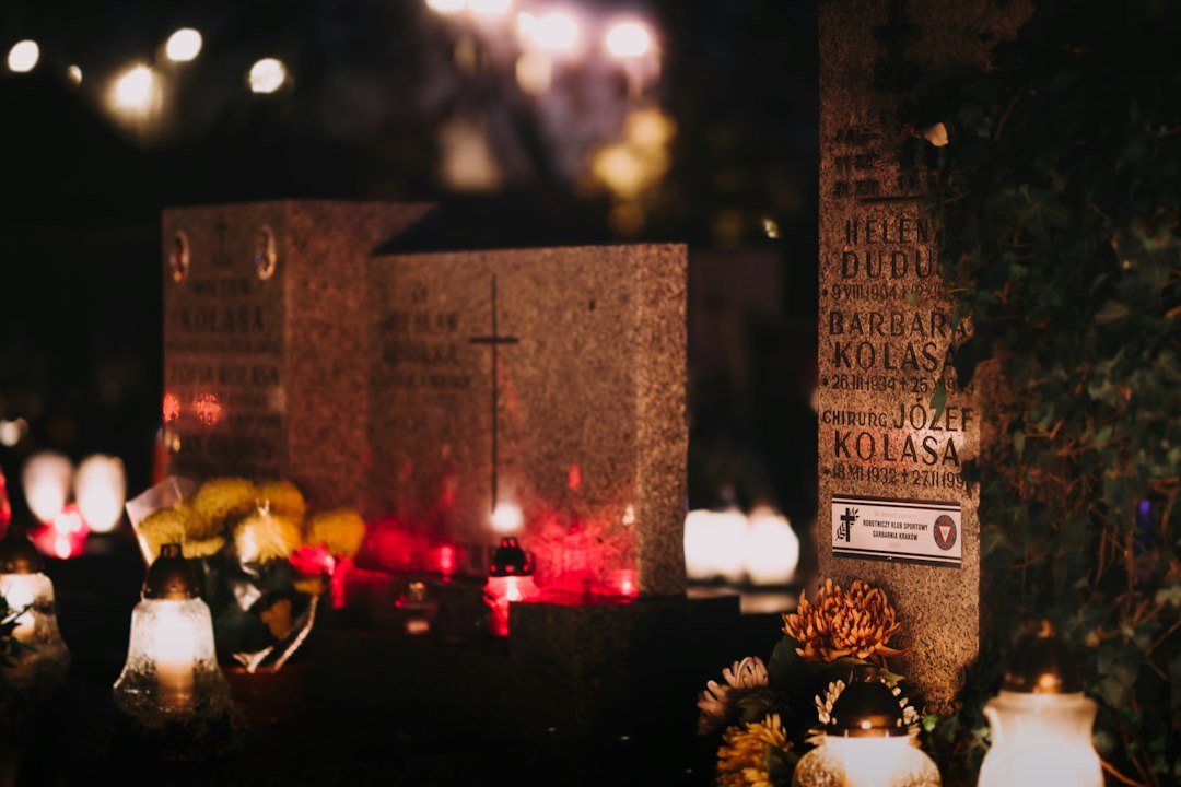 Cemetery at night illuminated by candles and flowers on decorated graves