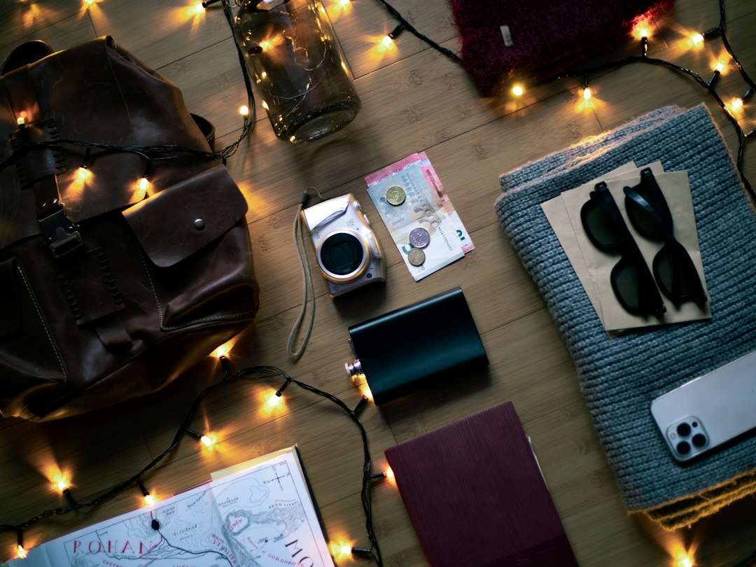 Travel accessories laid out with a backpack, passport, and camera