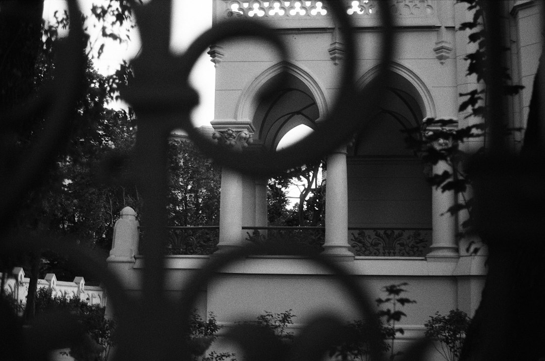 Ornate gothic revival stone mansion behind ironwork