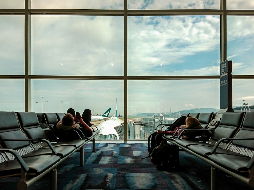 Travelers waiting at an airport gate surrounded by suitcases