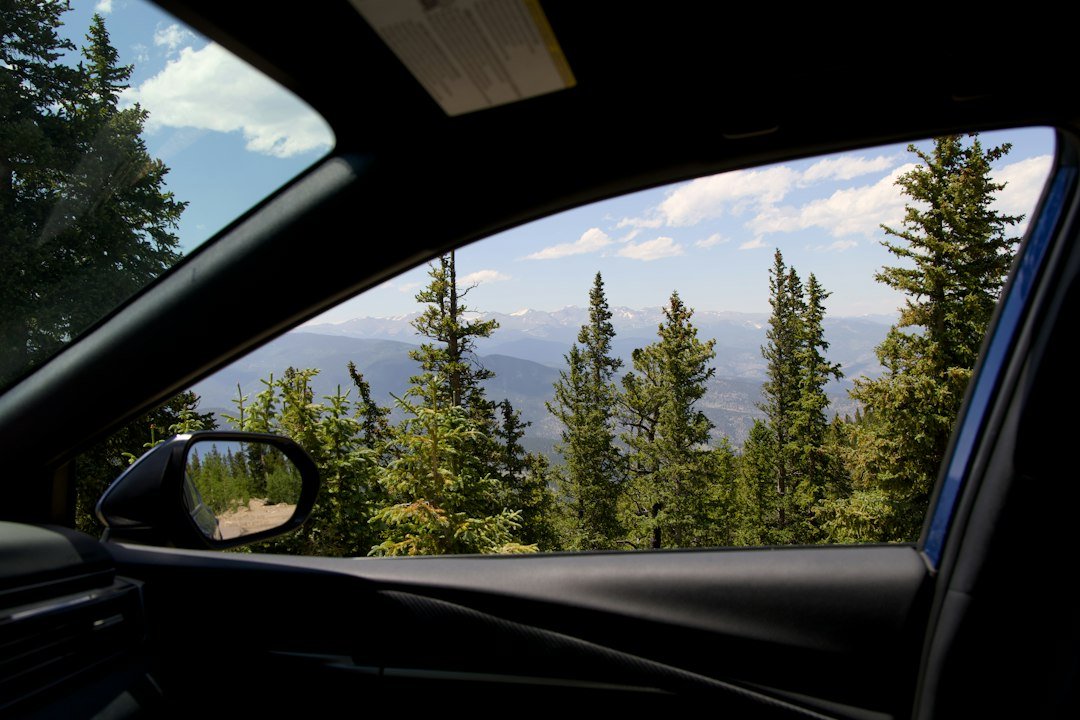 Snow-capped mountain range framed through a vehicle window