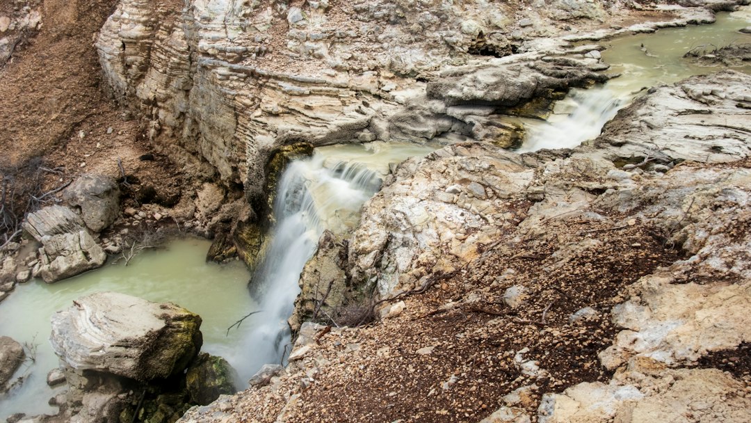 Steaming pools cascading below a waterfall at a hot springs