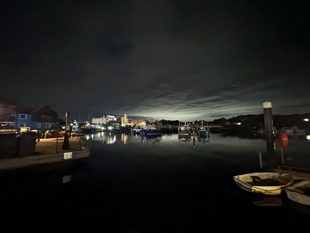 Small harbor town glowing at dusk with boats along the waterfront