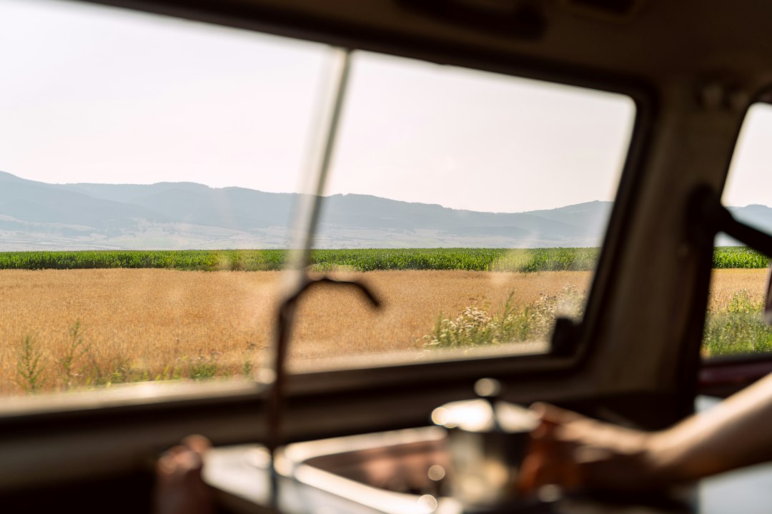 Campervan kitchen sink with faucet running and scenery visible through the window