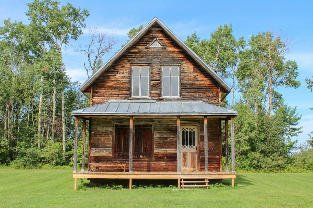 A weathered wooden cabin with a covered front porch