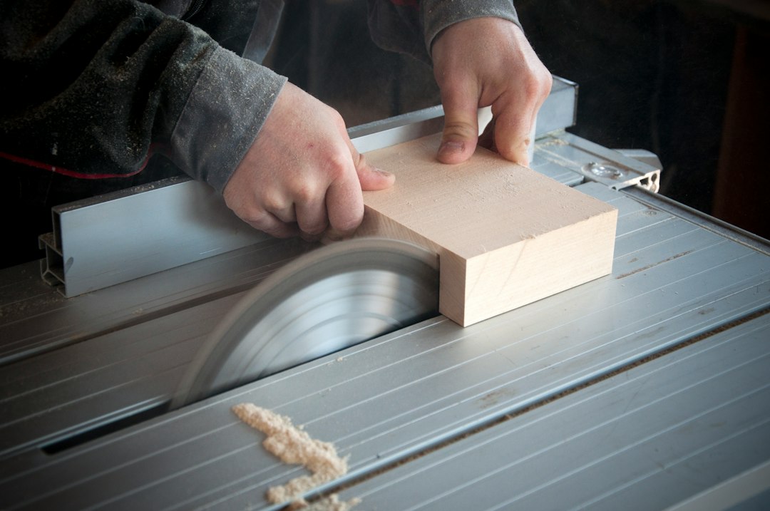 Cutting light-colored plywood sheet with sawdust flying