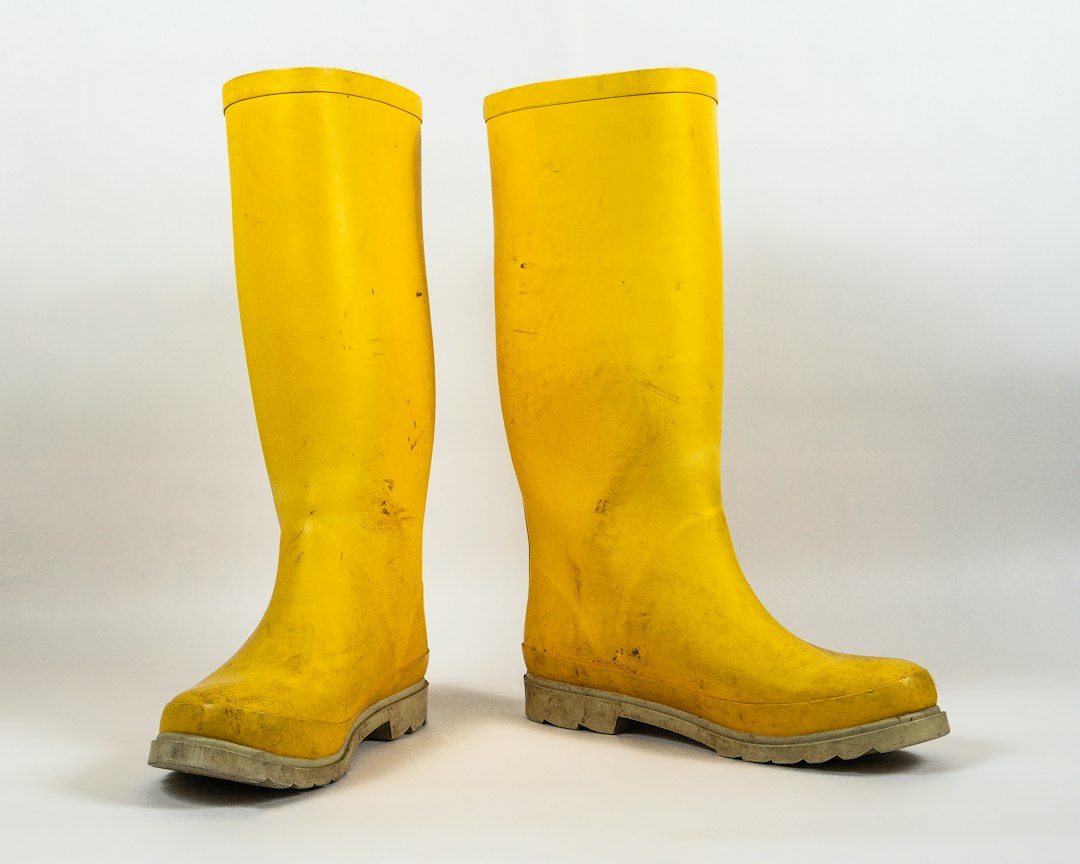 Well-worn yellow rubber boots standing ready for a muddy marsh morning