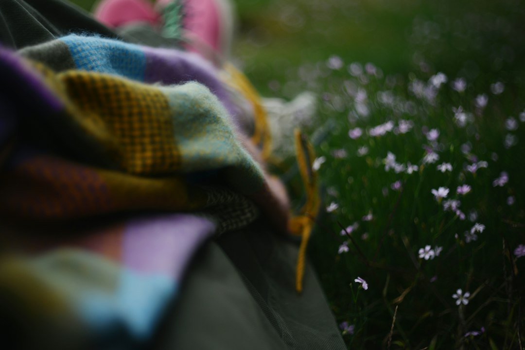 A thick knit blanket folded on grass before a cold night of stargazing